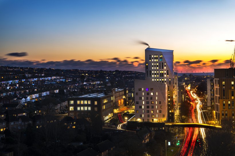 Lewes Road, Brighton, towards the sea at night with university buildings.